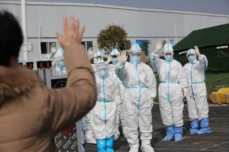 © Reuters. Funcionários de hospital com roupas de proteção acenam para paciente que recebeu alta de hospital após se recuperar do coronavírus