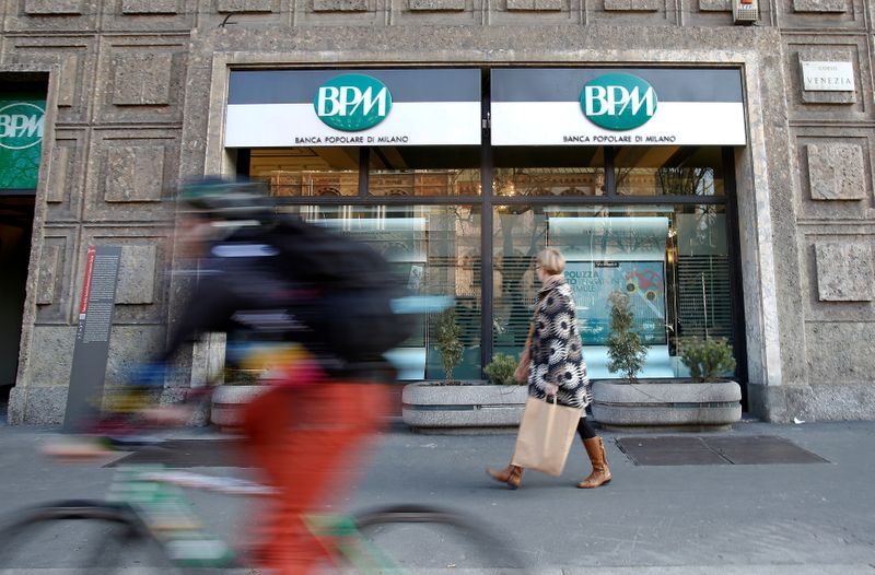 © Reuters. FILE PHOTO: A woman walks in front of the Banca Popolare di Milano (BPM) bank in downtown Milan