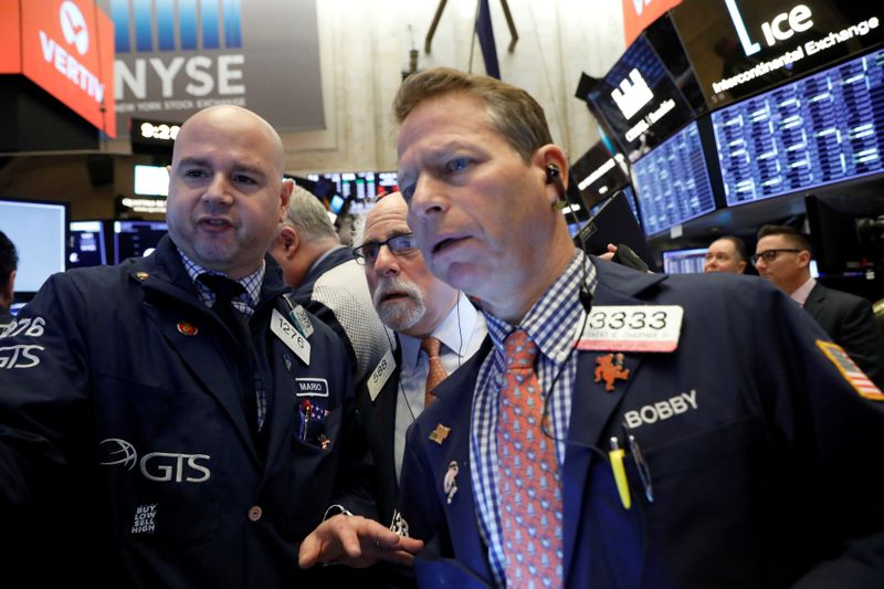 © Reuters. FILE PHOTO: Traders work on the floor at the NYSE in New York