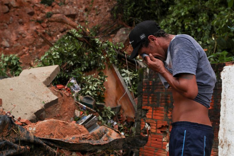 © Reuters. Homem chora em frente a deslizamento que matou 5 pessoas no Guarujá