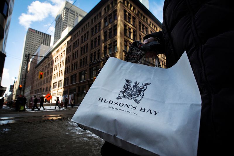 © Reuters. FILE PHOTO: FILE PHOTO: A woman holds a Hudson's Bay shopping bag in front of the Hudson's Bay Company (HBC) flagship department store in Toronto