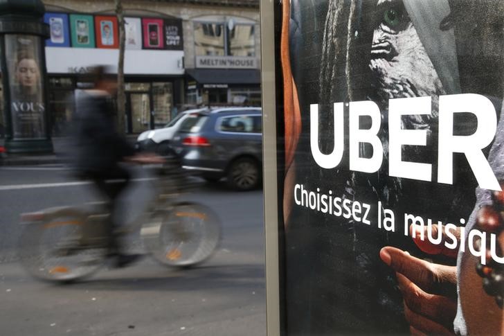 © Reuters. Carros passam por anúncio da Uber em avenida de Paris, França