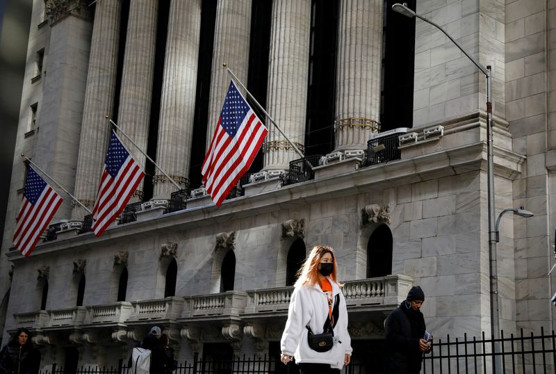 © Reuters. FILE PHOTO: A woman wears a mask near the NYSE in the Financial District in New York