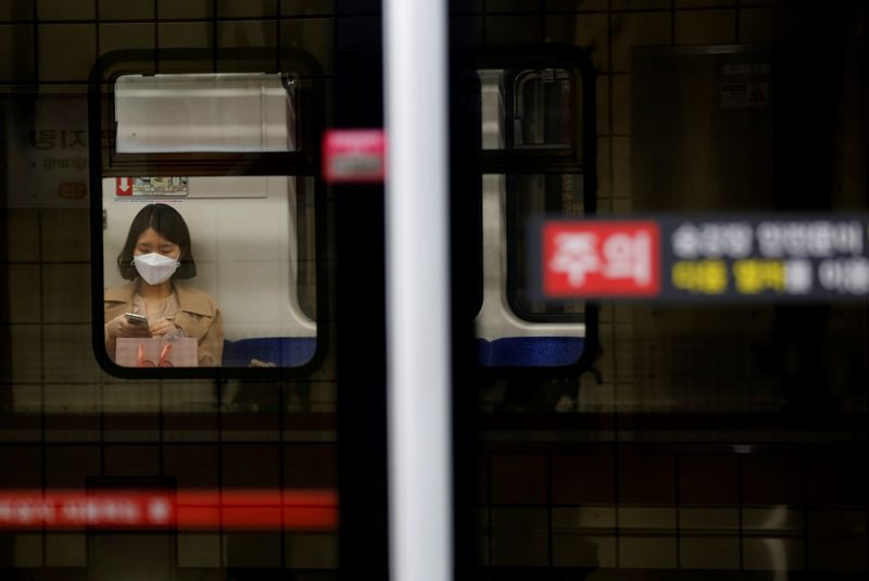 © Reuters. Woman wearing a face mask rides the subway amid the rise in confirmed cases of coronavirus disease (COVID-19) in Daegu