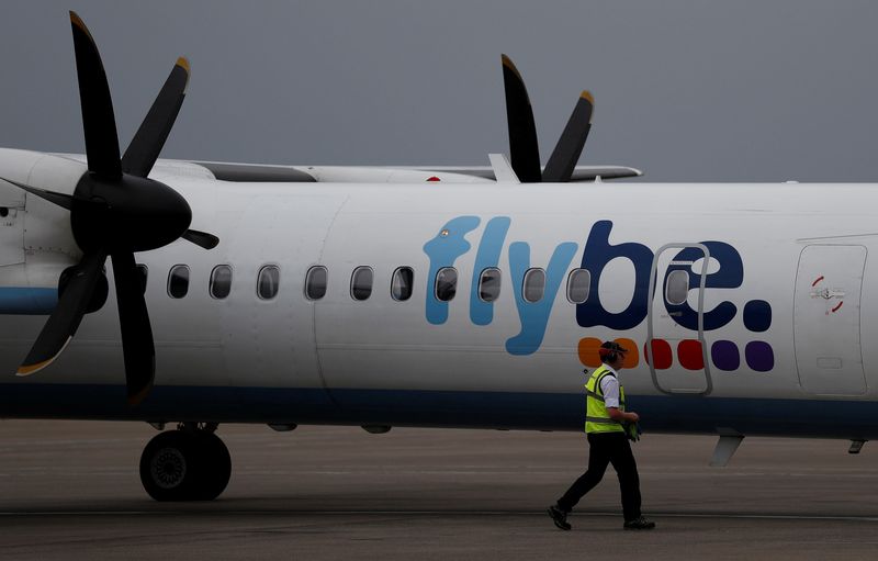 © Reuters. An airport worker examines a flybe aircraft before it takes off from Liverpool John Lennon Airport in Liverpool northern England.