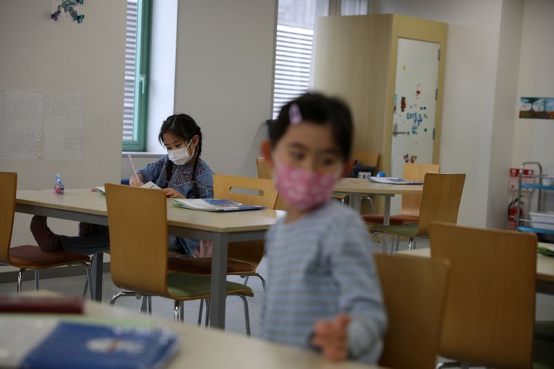 © Reuters. Crianças com máscara de proteção em escola de Tóquio