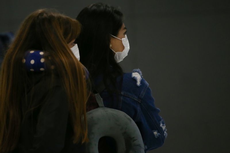 © Reuters. Passageiras usam máscara de proteção no aeroporto de Garulhos, em São Paulo