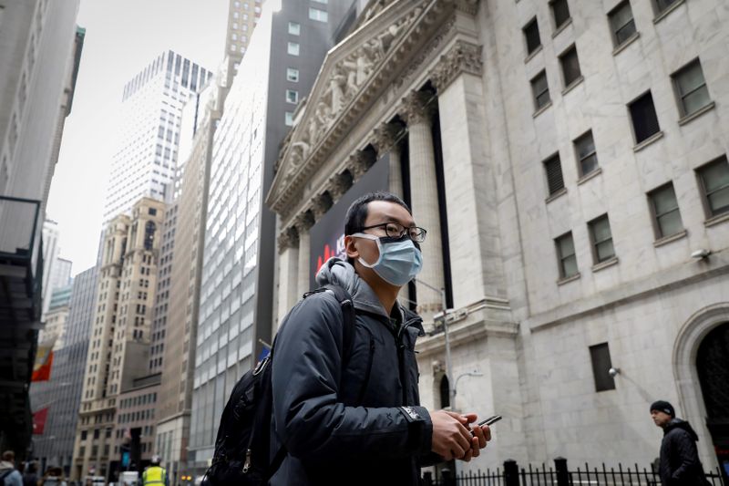 © Reuters. FILE PHOTO: A man wears a mask on Wall St. near the NYSE in New York