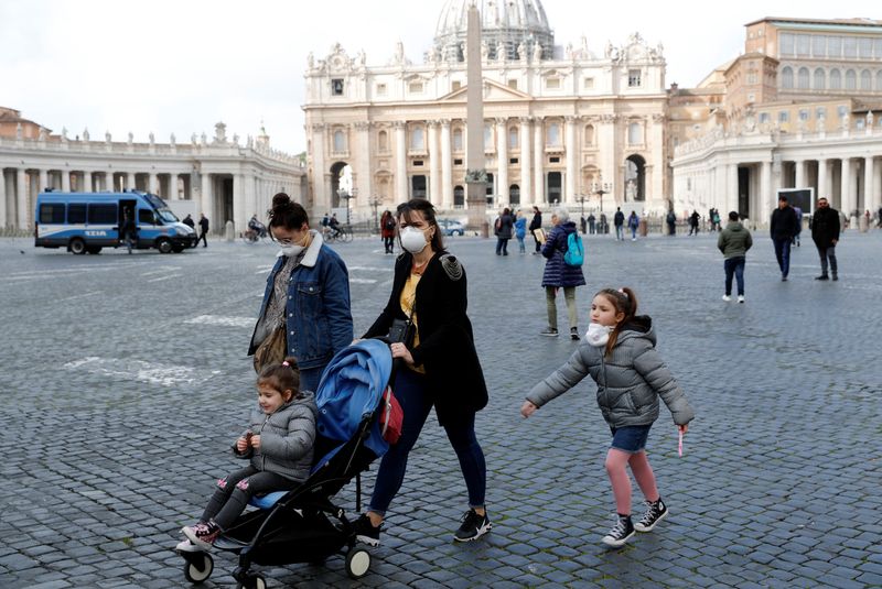 © Reuters. Diverse persone con maschere protettive a Piazza San Pietro a Città del Vaticano