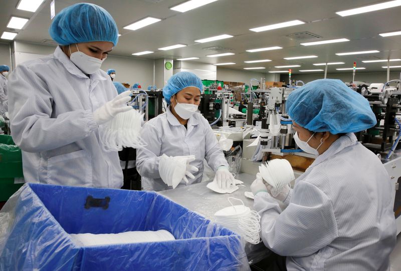 &copy; Reuters. Employees work at a mask factory in Icheon