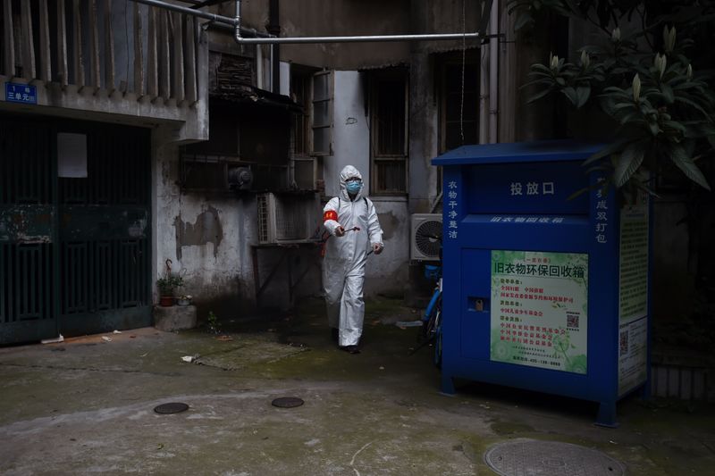 © Reuters. Community worker in protective suit disinfects a residential compound in Wuhan