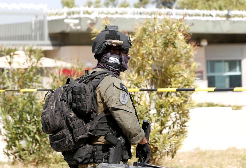 © Reuters. A member of the anti-terrorist brigade (BAT) walks outside the U.S. embassy after a suicide attack in Tunis