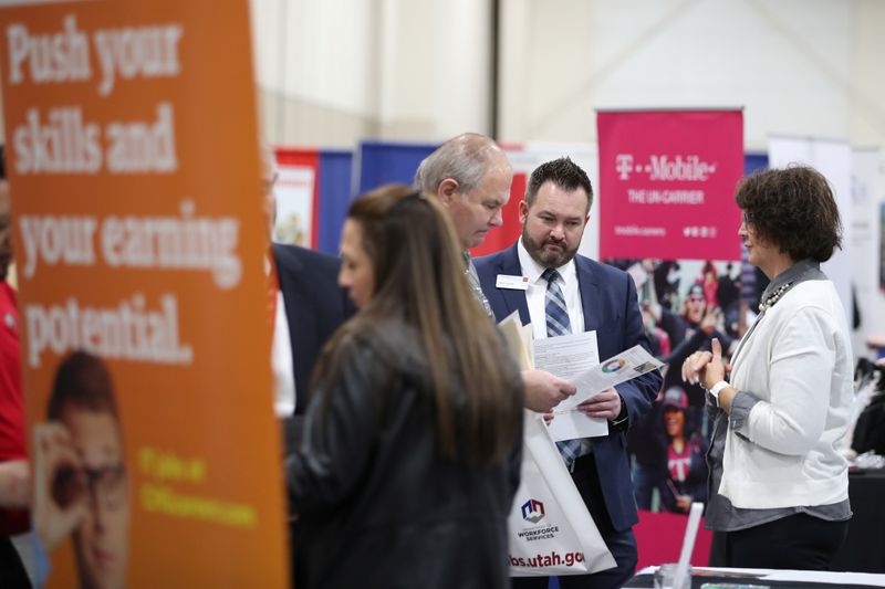 © Reuters. Veterans and military personnel discuss job opportunities at a military job fair in Sandy, Utah