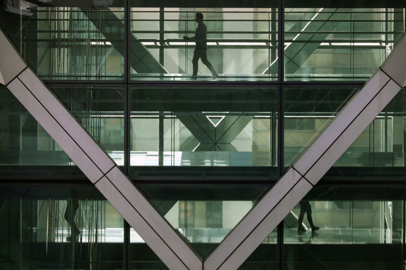 © Reuters. People walk in an office in the financial centre of Canary Wharf