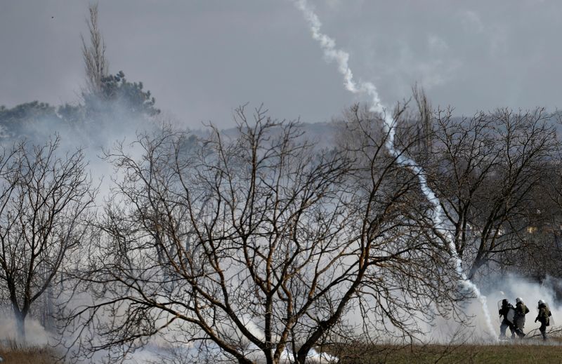 © Reuters. Greek riot police officers walk amid clouds of tear gas near Turkey's Pazarkule border crossing, in Kastanies