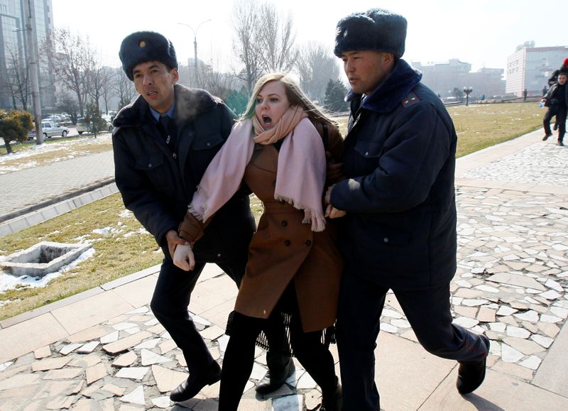 © Reuters. Kyrgyz law enforcement officers detain a women's rights activist during a rally in Bishkek