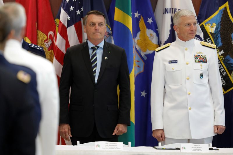 © Reuters. Brazilian President Jair Bolsonaro and Commander of the U.S. Southern Command Admiral Craig S. Faller attend an agreement signing ceremony, in Miami