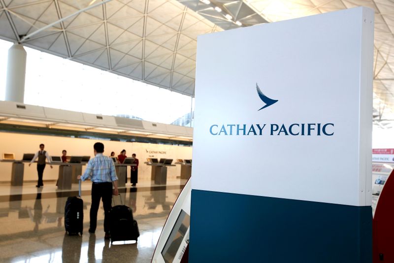 © Reuters. FILE PHOTO: A passenger walks to the First Class counter of Cathay Pacific Airways at Hong Kong Airport in Hong Kong