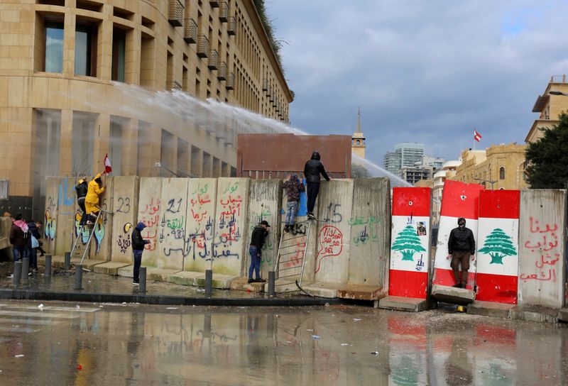 © Reuters. FILE PHOTO: Demonstrators are sprayed with a water cannon during a protest seeking to prevent MPs and government officials from reaching the parliament for a vote of confidence, in Beirut