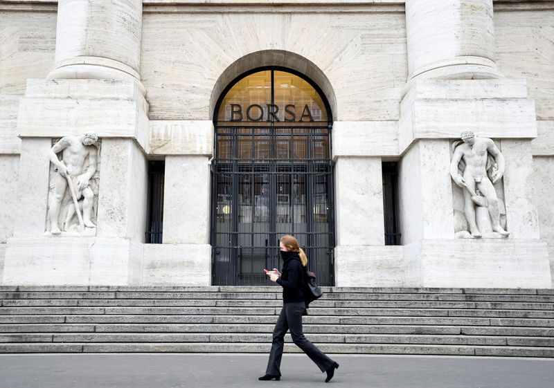 © Reuters. FILE PHOTO: Woman goes past the Italian Stock Exchange in Milan