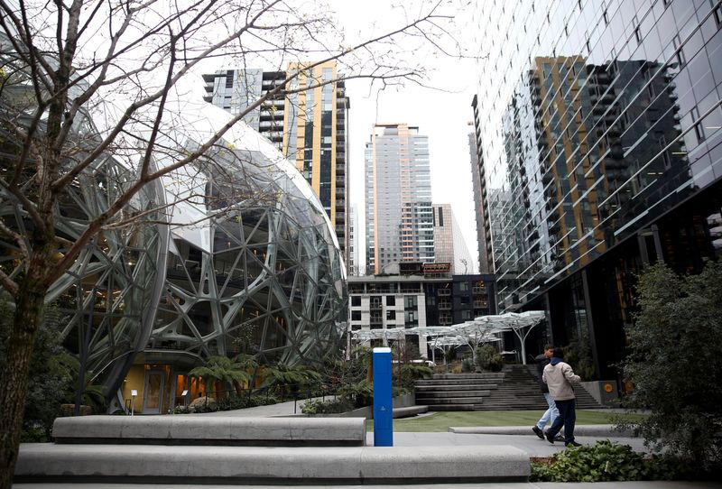 © Reuters. FILE PHOTO: People walk by the Amazon Spheres at the Amazon campus in downtown Seattle after the company asked employees to work from home for the rest of the month if possible