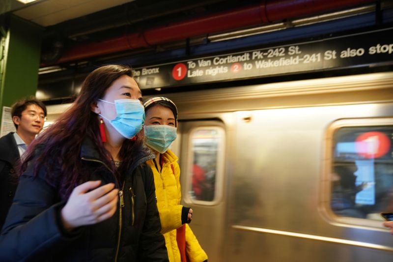 © Reuters. People wear surgical masks in the subway station at Times Square in New York