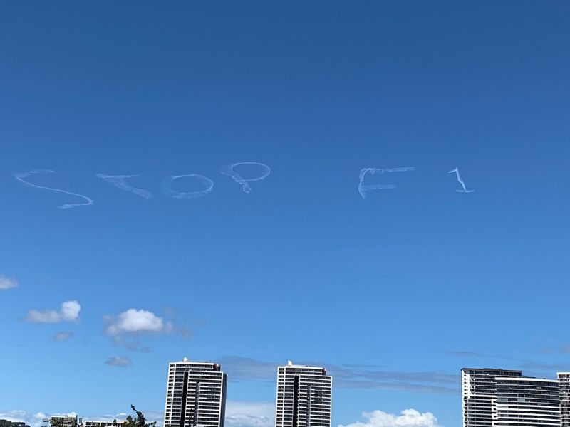 © Reuters. Skywriting in the sky which reads "Stop F1" in white smoke is seen in Sydney, Australia in this March 11, 2020 picture obtained from social media.