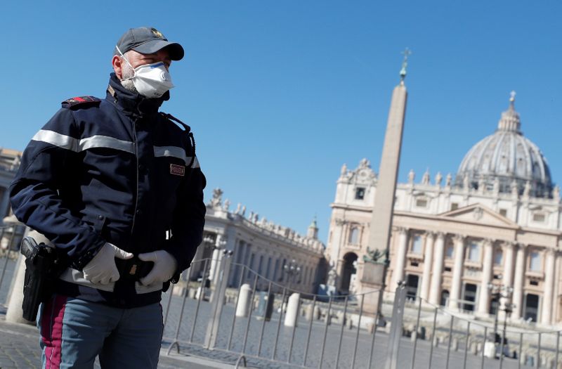 © Reuters. Un policía con mascarilla vigila una Plaza de San Pedro vacía desde Roma, Italia.