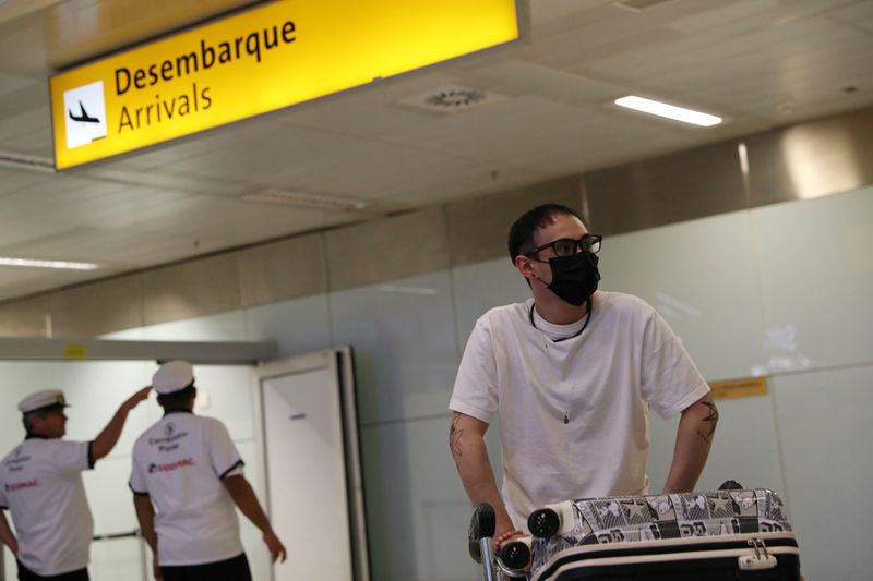 © Reuters. Passageiro com máscara de proteção contra coronavírus desembarca no aeroporto internacional de Guarulhos, em São Paulo
