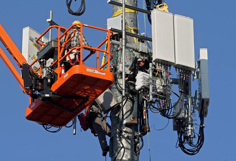 © Reuters. FILE PHOTO:  A contract crew from Verizon installs 5G equipment on a tower in Orem