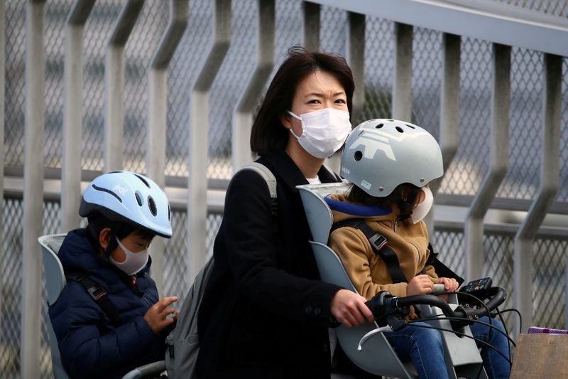 © Reuters. FILE PHOTO: People, wearing protective masks following an outbreak of the coronavirus disease (COVID-19), are pictured in Tokyo