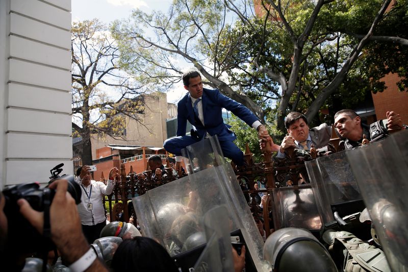 © Reuters. National Guard officers try to stop Venezuelan opposition leader Juan Guaido, who many nations have recognised as the country's rightful interim ruler, from entering Venezuela's National Assembly building in Caracas