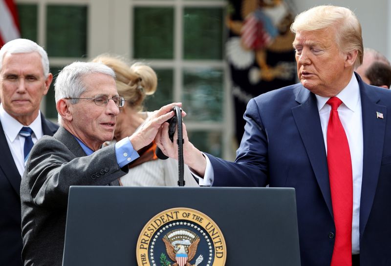 © Reuters. El presidente de Estados Unidos, Donald Trump, cede el microfono al director del Instituto Nacional de Alergias y Enfermedades Infecciosas, Anthony Fauci, para hablar sobre el coronavirus en la Casa Blanca. REUTERS/Jonathan Ernst