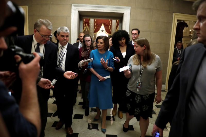 © Reuters. House Speaker Nancy Pelosi (D-CA) walks with reporters back to her office after speaking about a coronavirus economic aid package on Capitol Hill in Washington