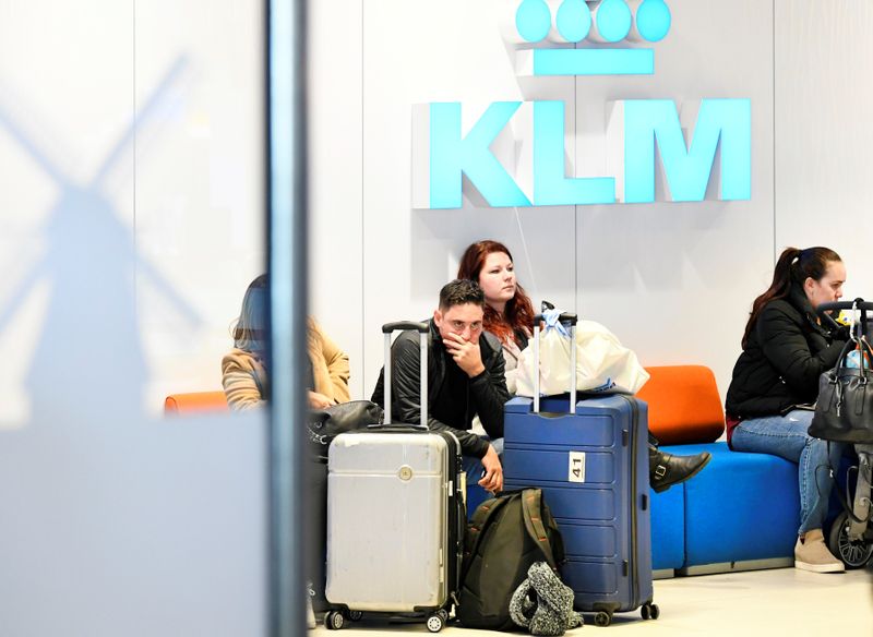 © Reuters. Travelers wait to be informed in the departure hall at the KLM Service Desk at Schiphol