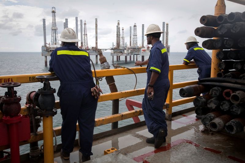 © Reuters. FILE PHOTO: Crew members look over idle oil rigs in the Gulf of Mexico near Port Fourchon, Louisiana