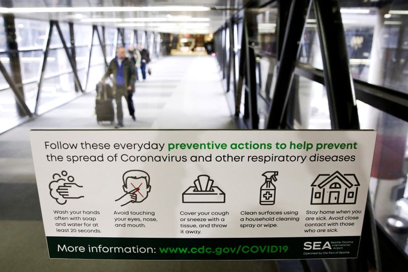 © Reuters. FILE PHOTO: A sign featuring preventative actions to stop the spread of Coronavirus is pictured at Seattle-Tacoma International Airport as passengers exit the main terminal, in SeaTac, Washington