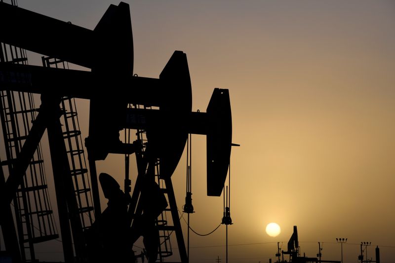 © Reuters. FILE PHOTO: Pump jacks operate at sunset in Midland