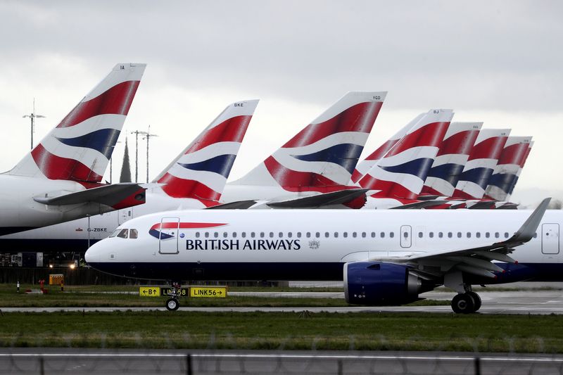 © Reuters. BA plane taxis past tail fins of parked aircraft to runway near Terminal 5 at Heathrow Airport