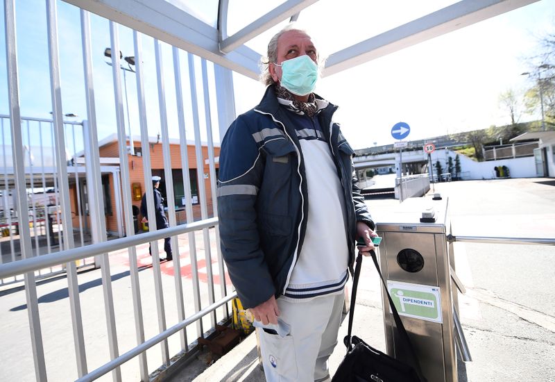 © Reuters. FILE PHOTO: Fiat Chrysler Automobiles (FCA) worker, wearing a protective face mask, leaves a Mirafiori plant, after the Italian government puts the whole country on lockdown as new coronavirus cases surge, in Turin