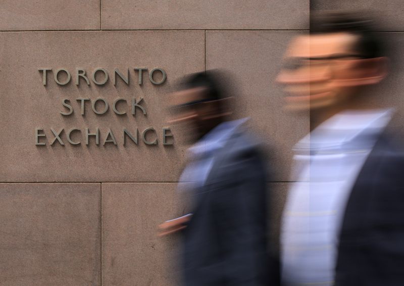 © Reuters. FILE PHOTO: Businessmen pass the Toronto Stock Exchange sing in Toronto