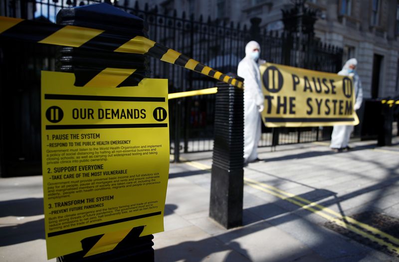 © Reuters. Protesters from organization "Pause the System" wearing hazmat suits demonstrate against government's response to the coronavirus crisis, outside Downing Street in London