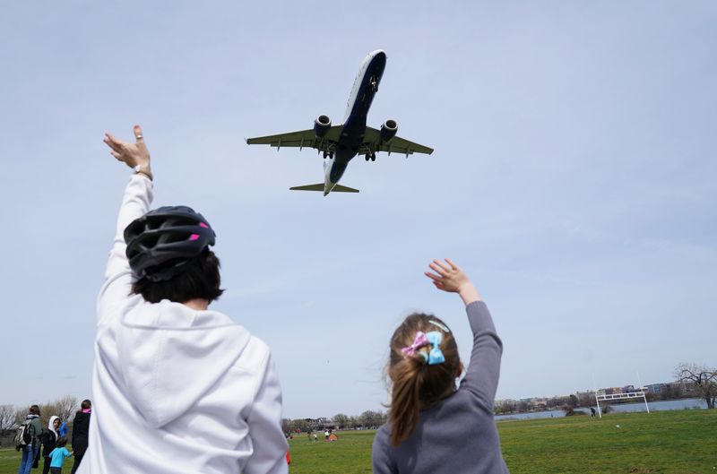 © Reuters. People wave to a plane landing in Ronald Reagan Washington National Airport