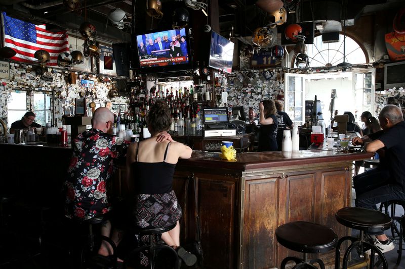 © Reuters. People watch U.S. President Donald Trump speak on a television inside a Bourbon St. bar in New Orleans