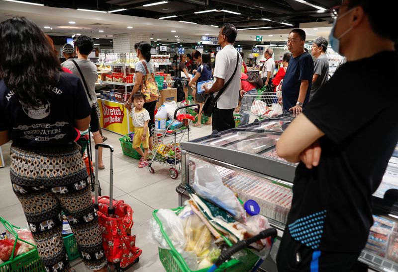 © Reuters. People buy food at a supermarket in Singapore