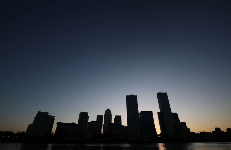 © Reuters. FILE PHOTO:  The sun rises behind the Canary Wharf financial district in London