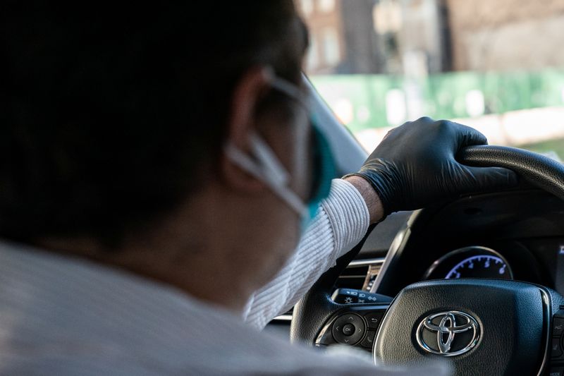 © Reuters. Motorista de Uber utiliza máscara de proteção e luvas em Nova York em meio à pandemia de coronavírus