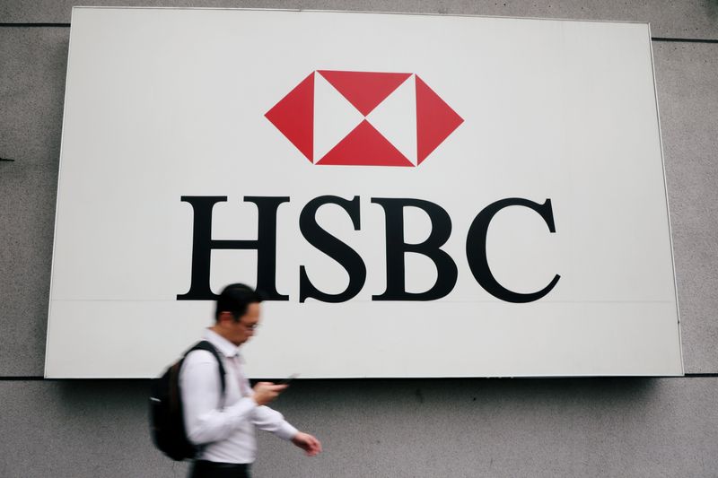 © Reuters. FILE PHOTO: A man walks past a logo of HSBC at its headquarters in Kuala Lumpur