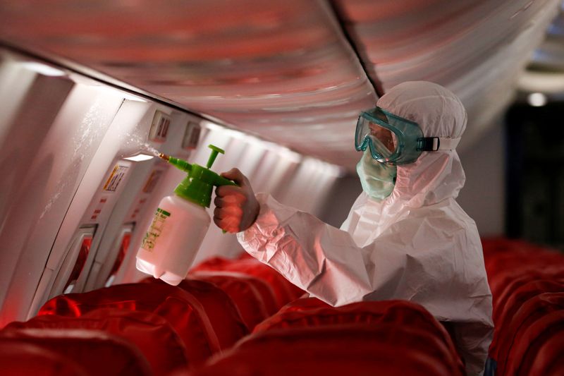 © Reuters. A cleaning worker sprays disinfectant inside the cabin of a Lion Air's Boeing 737-800 at Soekarno-Hatta International Airport