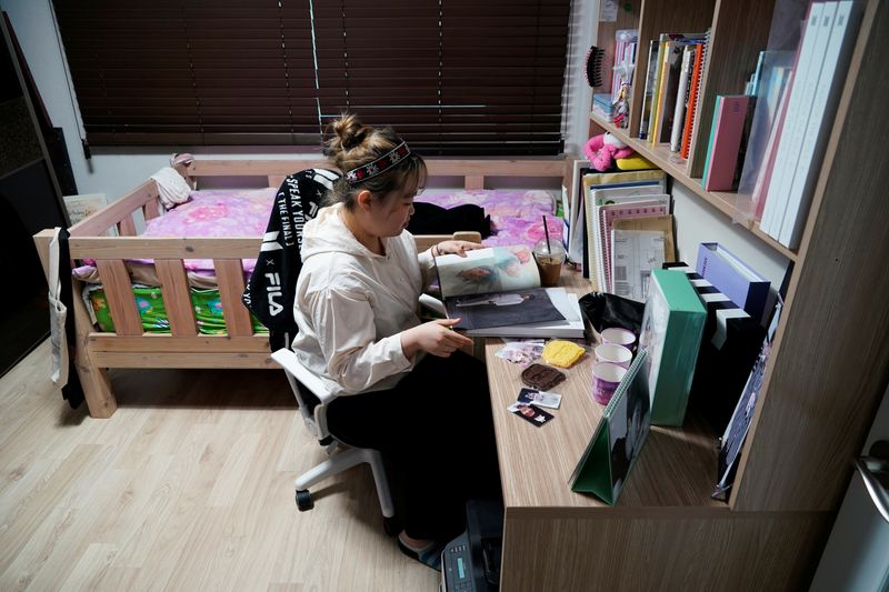 © Reuters. Im Yu-mi, fan of K-pop boy band BTS, looks at one of their albums at her home in Seoul, South Korea